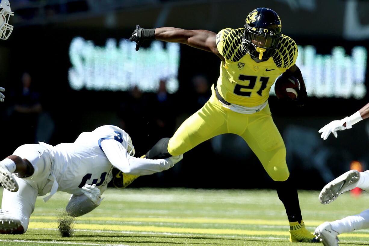 Oregon running back Royce Freeman (21) shakes the grasp of Georgia State's Tarris Batiste on Saturday, Sept. 19, 2015, in Eugene, Ore.