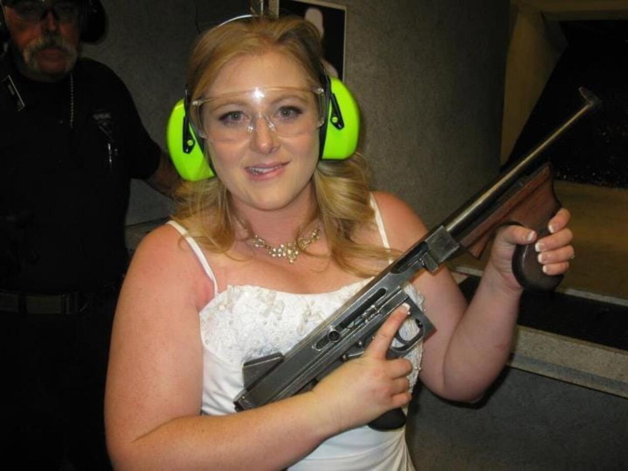 Lindsae MacDuff holds an automatic weapon July 28, 2012, at the Gun store in Las Vegas after her &quot;shotgun wedding.&quot; Tourists from Japan flock to ranges in Waikiki, Hawaii, and the dozen or so that have cropped up in Las Vegas offer bullet-riddled bachelor parties and literal shotgun weddings, where newly married couples can fire submachine gun rounds and pose with Uzis and ammo belts.