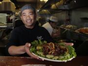 Chef Sambath Neang of Cambodian restaurant Simply Khmer presents a beef loc lac plate during lunchtime in Lowell, Mass.