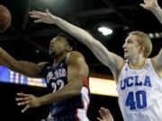 Gonzaga guard Byron Wesley, left, shots around UCLA center Thomas Welsh during the first half in Los Angeles, Saturday, Dec. 13, 2014.