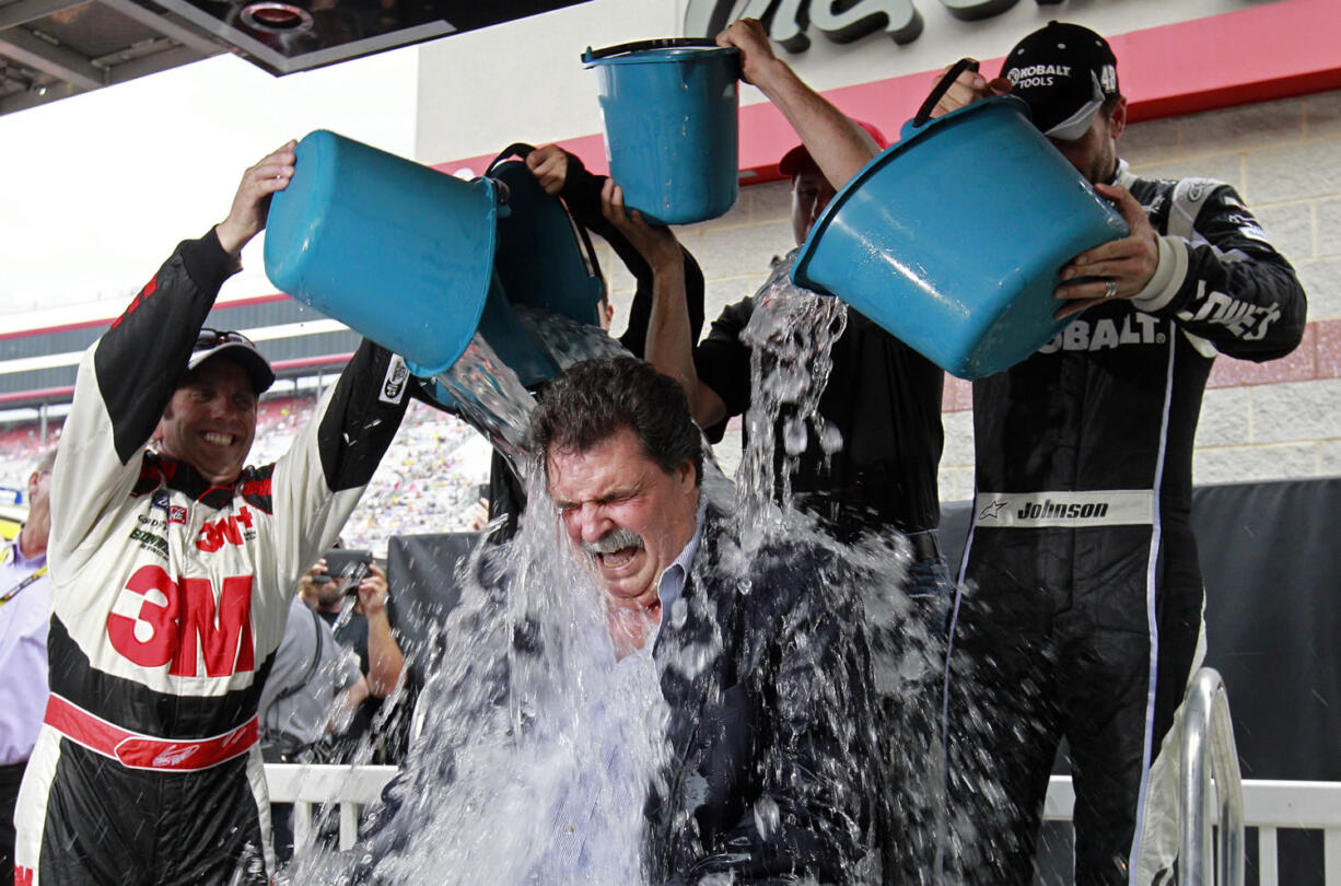 NASCAR President Mike Helton has buckets of ice water dumped on him by drivers Greg Biffle, left, Danica Patrick, Jamie McMurry and Jimmie Johnson as part of the Ice Bucket Challenge to raise money for ALS, at Bristol Motor Speedway in Bristol, Tenn.