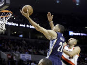 Memphis Grizzlies forward Tayshaun Prince, left, drives to the hoop past Portland Trail Blazers forward Nicolas Batum during the first half of an NBA basketball game in Portland on Tuesday.