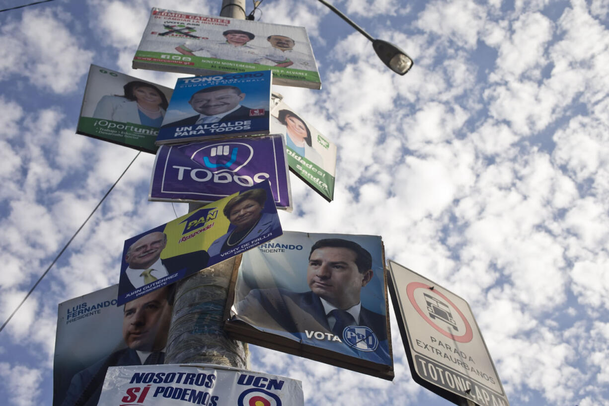 Political campaign posters fill a lamp post in Guatemala City, Saturday, Sept. 5, 2015. Voters go to the polls Sunday for normally scheduled general elections, less than a week after Otto Perez Molina resigned as president.