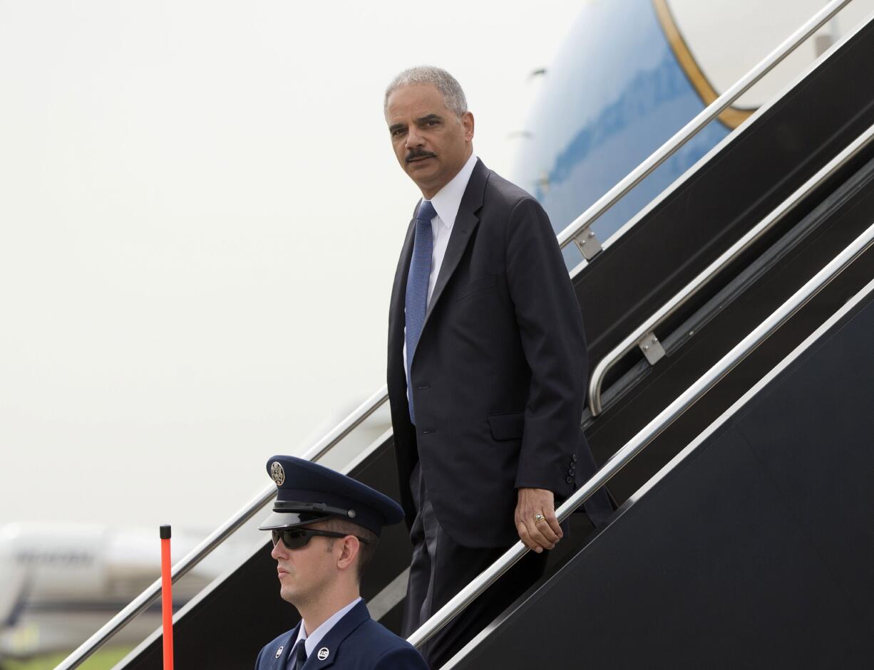 Attorney General Eric Holder arrives on a military aircraft at Lambert-St. Louis International Airport in St.