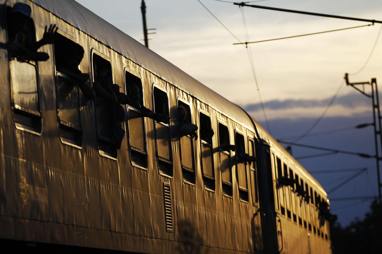 Migrants look out of windows after boarding a train at a station in the village of Zakany, Hungary, on Wednesday. Deeply divided European Union leaders have been called to an emergency summit to seek long-term responses to the continent's ballooning crisis of refugees and migrants, a historic challenge EU President Donald Tusk said the bloc has failed dismally to meet.