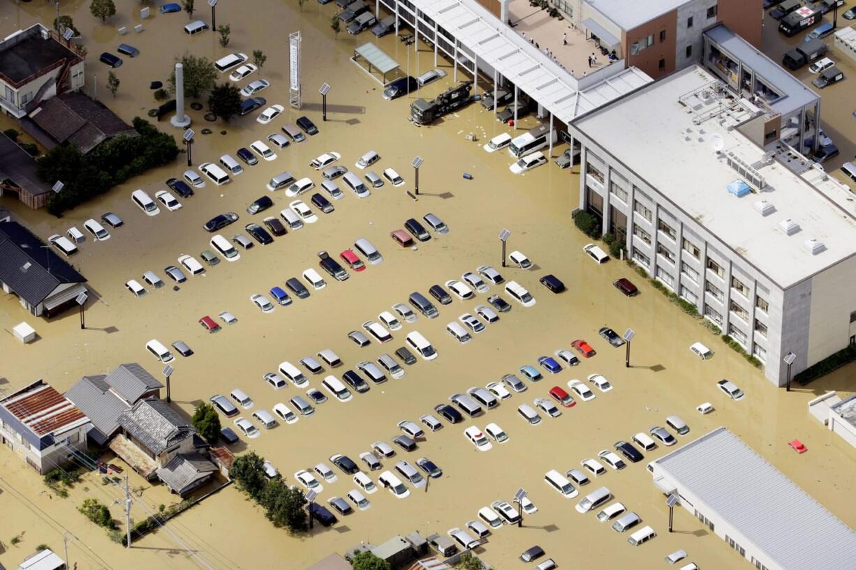 Vehicles are submerged in front of a city hall building in Joso, Ibaraki prefecture, northeast of Tokyo, Friday, Sept. 11, 2015. Two days of torrential rain caused flooding and landslides across much of Japan this week.