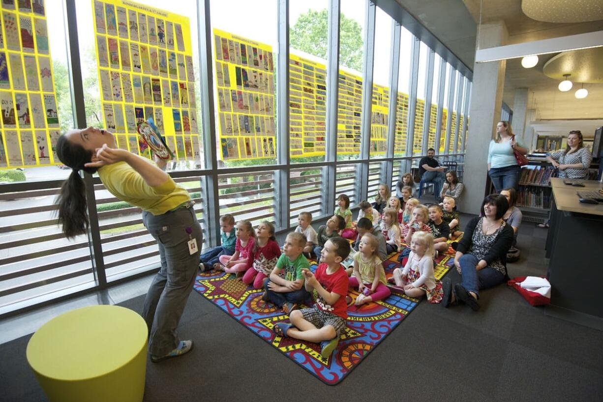 Elsbeth Casimir with the children's services department at the Vancouver Community Library reads the book &quot;Shark in the Park&quot; during a story time program.