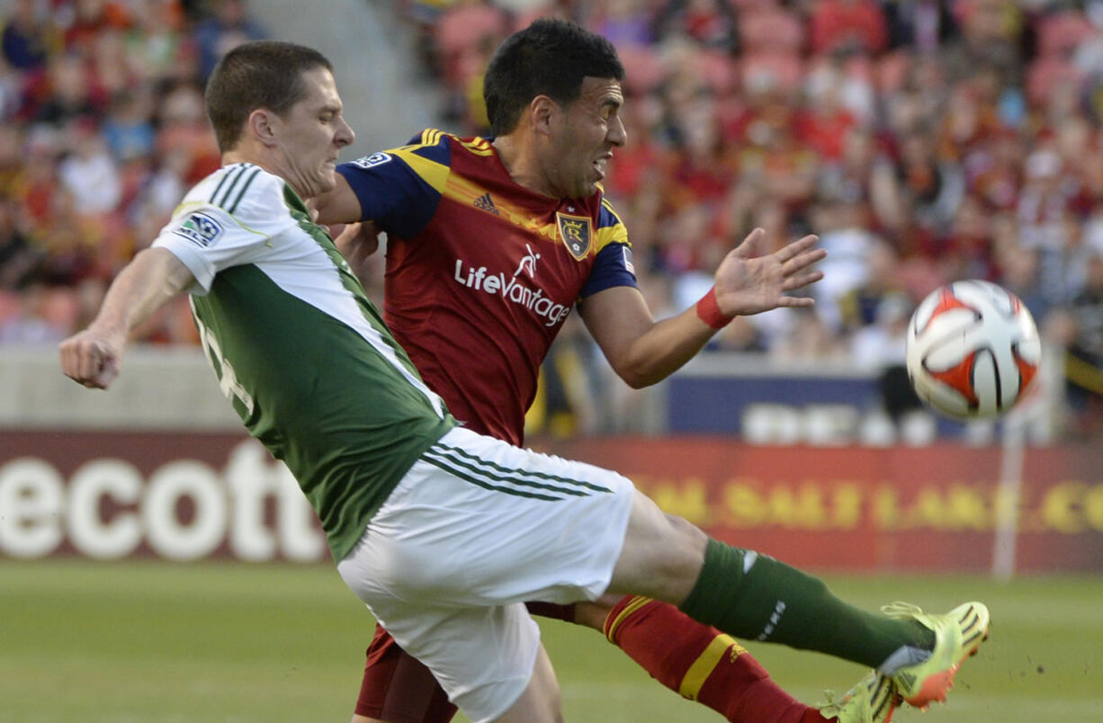 Real Salt Lake midfielder Javier Morales, right, defends as Portland Timbers midfielder Will Johnson kicks the ball downfield, in an MLS soccer game, Saturday, April 19, 2014, in Sandy, Utah.