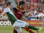 Real Salt Lake midfielder Javier Morales, right, defends as Portland Timbers midfielder Will Johnson kicks the ball downfield, in an MLS soccer game, Saturday, April 19, 2014, in Sandy, Utah.