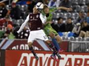 Colorado Rapids midfielder Dillon Serna, left, tries to head the ball with Seattle Sounders midfielder Andy Rose in the second half Saturday, April 18, 2015, in Commerce City, Colo. Seattle won 3-1.