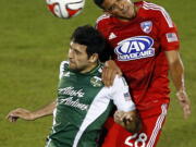 FC Dallas midfielder Victor Ulloa (28) and Portland Timbers midfielder Diego Valeri (8) go up for a header in the first half of an MLS soccer game at Toyota Stadium in Frisco, Texas, on Saturday, March 29, 2014.