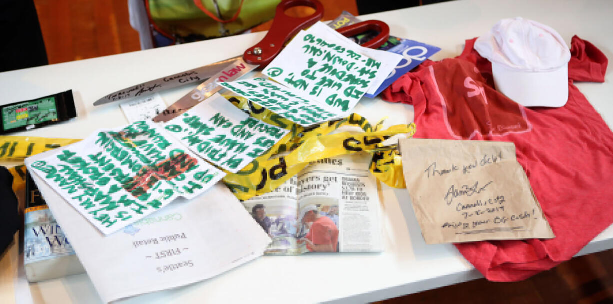 Items Deb Greene, a 65-year-old Ballard grandmother, donated to the Museum of History and Industry in Seattle on July 22 include two grams of the Sweet Lafayette strain of cannabis, upper left, part of Seattle's first legal pot purchase, along with clothes she wore and the book she read as she waited for 21 hours at the front of the line, all of which will go into MOHAI's permanent collection.