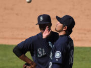 Seattle Mariners starting pitcher Hisashi Iwakuma tosses the ball in the air as he waits to be taken out of the game as shortstop Ketel Marte watches during the eighth inning against the Los Angeles Angels, Sunday, Sept. 27, 2015, in Anaheim, Calif. (AP Photo/Mark J.