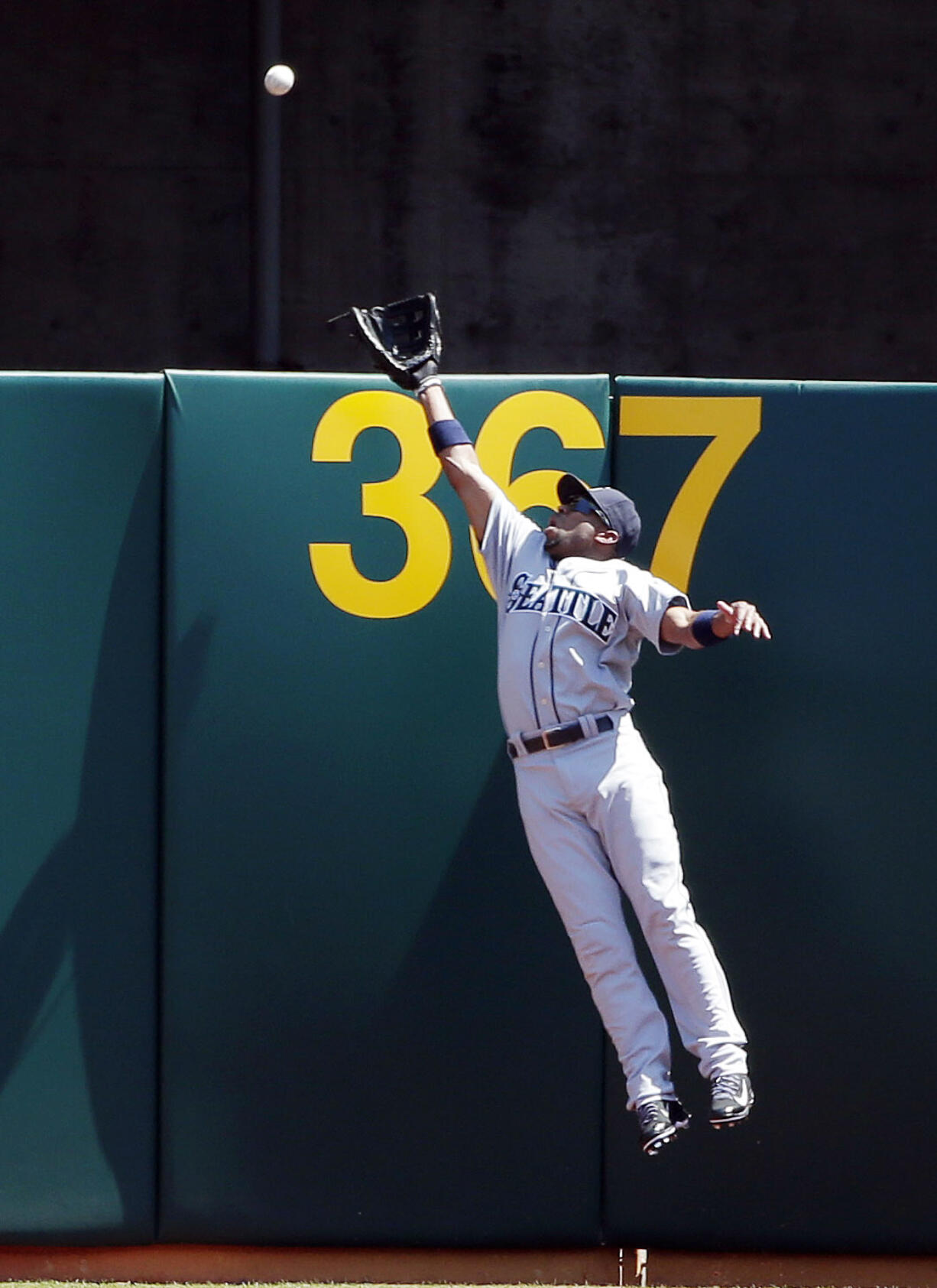 Seattle Mariners right fielder Endy Chavez leaps but can't catch a home run ball from Oakland Athletics' Adam Dunn during the first inning Monday in Oakland, Calif.