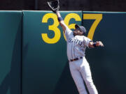 Seattle Mariners right fielder Endy Chavez leaps but can't catch a home run ball from Oakland Athletics' Adam Dunn during the first inning Monday in Oakland, Calif.