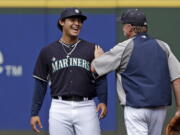 Seattle Mariners' Alex Jackson, left, a newly signed draft pick, talks with pitching coach Rick Waits after taking part in batting practice with the team Monday.