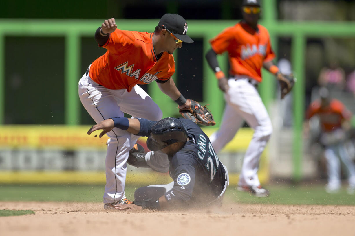 Miami Marlins second baseman Donovan Solano (17) tags Seattle Mariners runner Robinson Cano (22) out, stealing at second on eighth inning of a baseball game in Miami, Sunday, April 20,2014. The Marlins won 3-2.