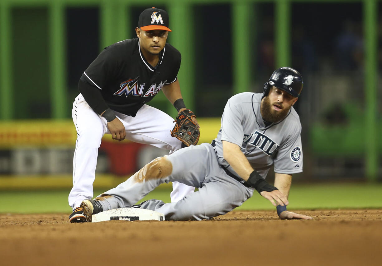 After tagging out Seattle Mariners' Dustin Ackley, right, Miami Marlins' Donovan Solano looks to first base as he turns the double play in the sixth inning Saturday.