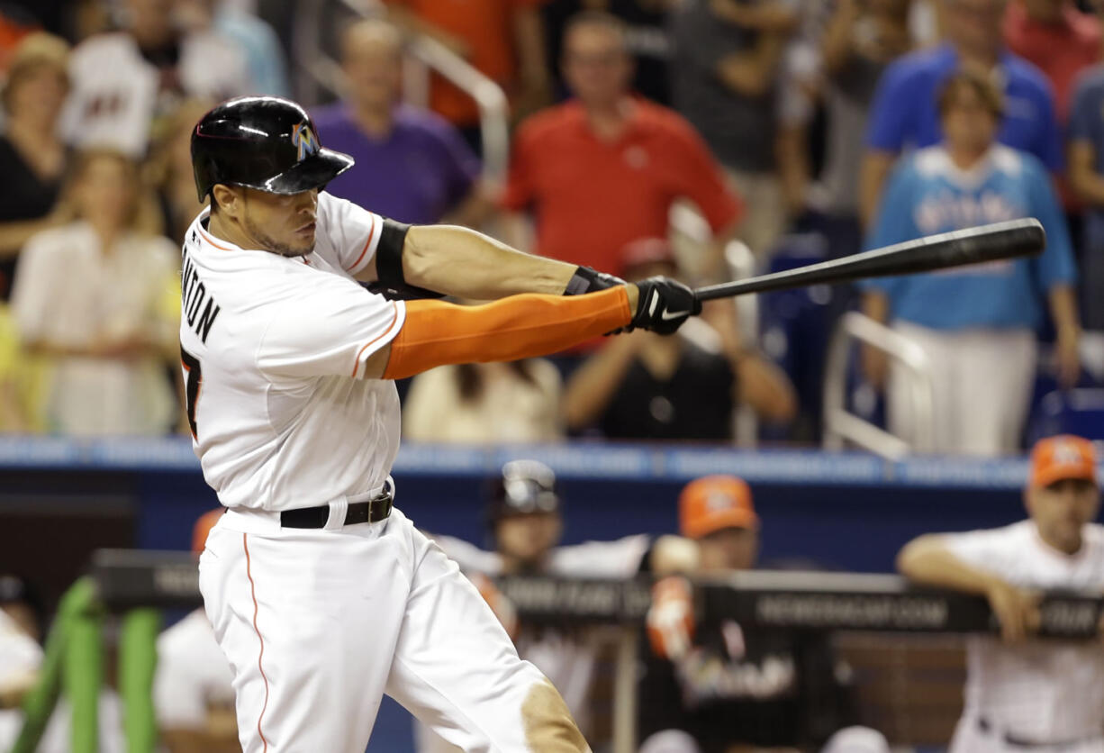 Miami Marlins' Giancarlo Stanton hits a grand slam to defeat the Seattle Mariners 8-4 during the ninth inning of an interleague baseball game on Friday, April 18, 2014, in Miami.