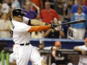 Miami Marlins' Giancarlo Stanton hits a grand slam to defeat the Seattle Mariners 8-4 during the ninth inning of an interleague baseball game on Friday, April 18, 2014, in Miami.