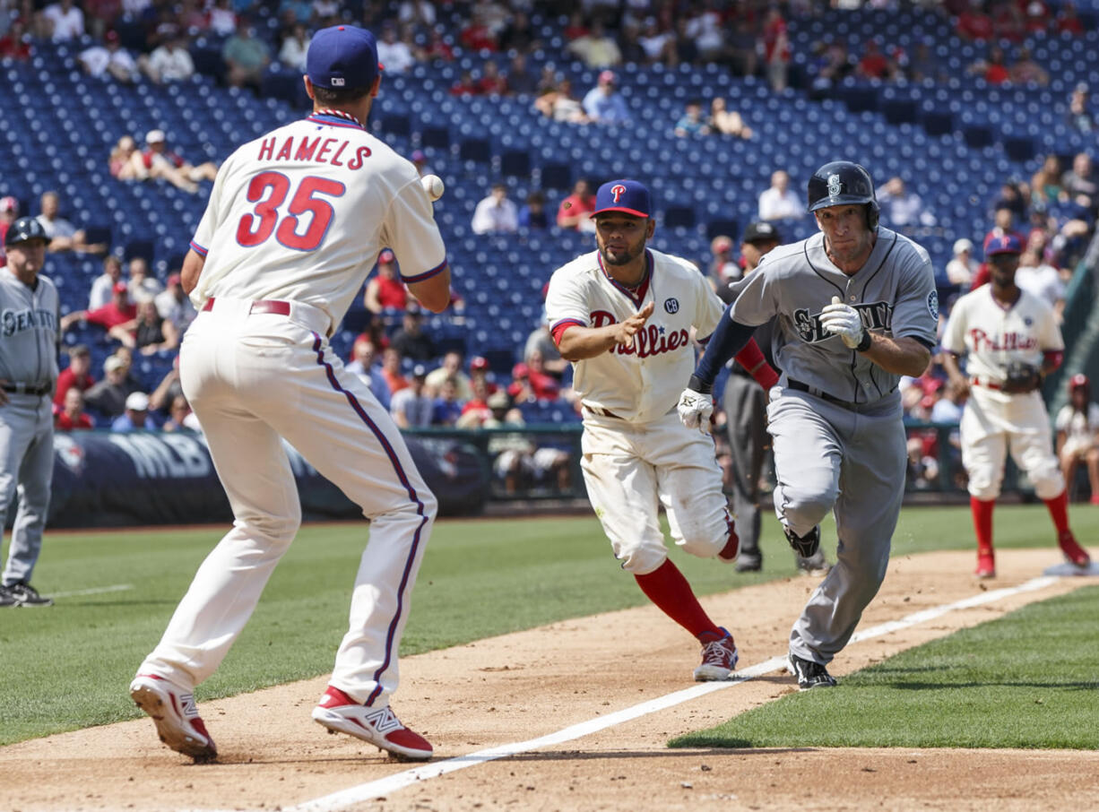 Philadelphia Phillies third baseman Andres Blanco, center, throws the ball to starting pitcher Cole Hamels, left, as they catch Seattle Mariners' Chris Denorfia, right, stealing during the fourth inning of a baseball game, Wednesday, Aug. 20, 2014, in Philadelphia.