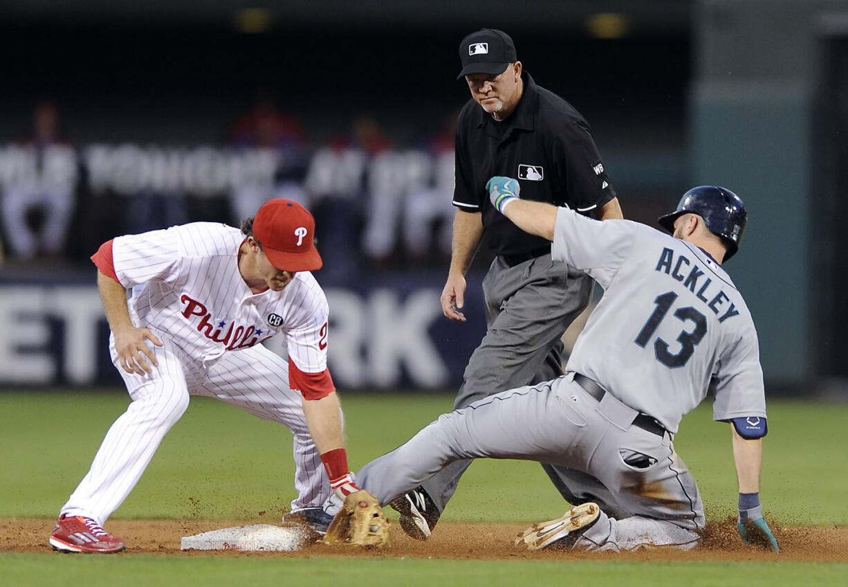 Seattle Mariners' Dustin Ackley (13) hits a double to left field and slides ahead of a tag from Philadelphia Phillies second baseman Chase Utley in the third inning of an interleague baseball game on Monday, Aug. 18, 2014, in Philadelphia.