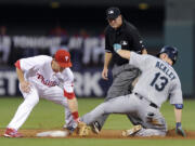 Seattle Mariners' Dustin Ackley (13) hits a double to left field and slides ahead of a tag from Philadelphia Phillies second baseman Chase Utley in the third inning of an interleague baseball game on Monday, Aug. 18, 2014, in Philadelphia.