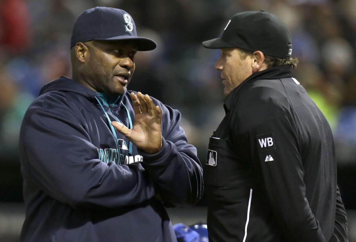 Seattle Mariners manager Lloyd McClendon, left, challenges a call by home plate umpire Paul Schrieber during the sixth inning of a baseball game against the Texas Rangers Monday, April 14, 2014, in Arlington, Texas. The Mariners challenged the force play called out at home plate and it was over overturned on video review.