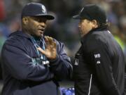 Seattle Mariners manager Lloyd McClendon, left, challenges a call by home plate umpire Paul Schrieber during the sixth inning of a baseball game against the Texas Rangers Monday, April 14, 2014, in Arlington, Texas. The Mariners challenged the force play called out at home plate and it was over overturned on video review.