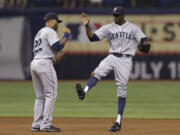 Seattle Mariners center fielder James Jones, right, celebrates with second baseman Robinson Cano after the team defeated the Tampa Bay Rays 7-4 Saturday in St.