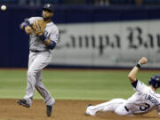 Seattle Mariners second baseman Robinson Cano, left, forces Tampa Bay Rays' Evan Longoria at second base and turns an unassisted double play on James Loney during the seventh inning of a baseball game Monday, June 9, 2014, in St. Petersburg, Fla.