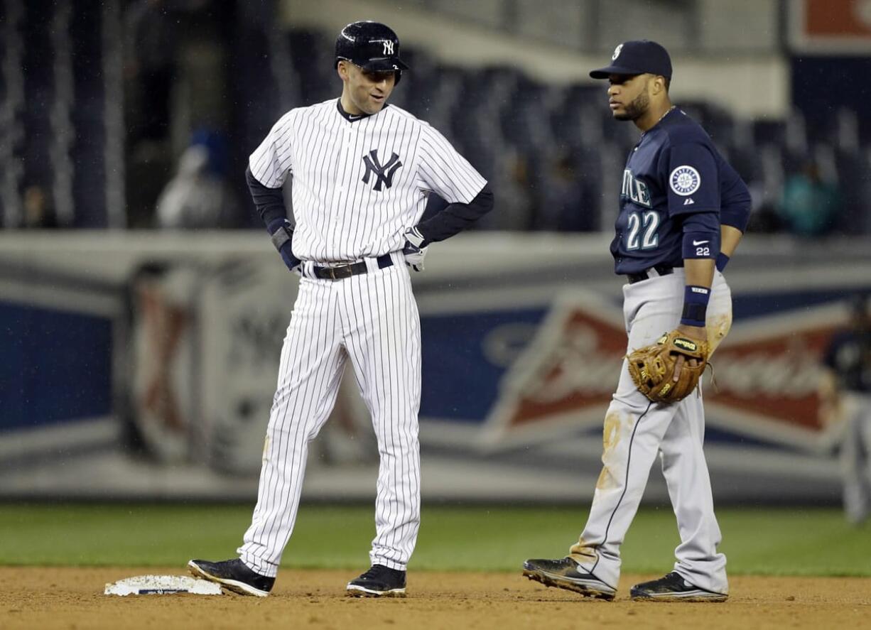 New York Yankees' Derek Jeter talks to Seattle Mariners second baseman Robinson Cano during the eighth inning of a baseball game Tuesday, April 29, 2014, in New York.