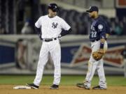 New York Yankees' Derek Jeter talks to Seattle Mariners second baseman Robinson Cano during the eighth inning of a baseball game Tuesday, April 29, 2014, in New York.