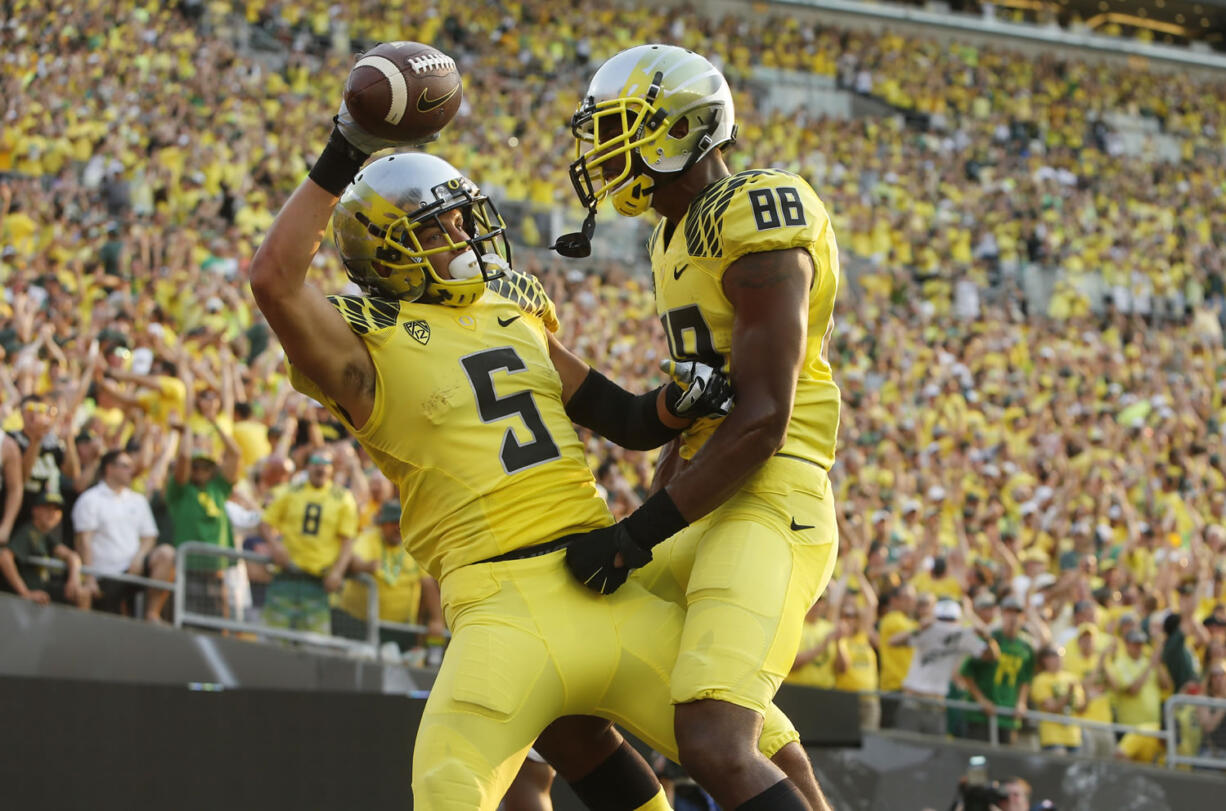 Oregon's Devon Allen, left, celebrates with teammate Dwayne Stanford after scoring in the 3rd quarter against