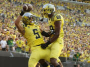 Oregon's Devon Allen, left, celebrates with teammate Dwayne Stanford after scoring in the 3rd quarter against