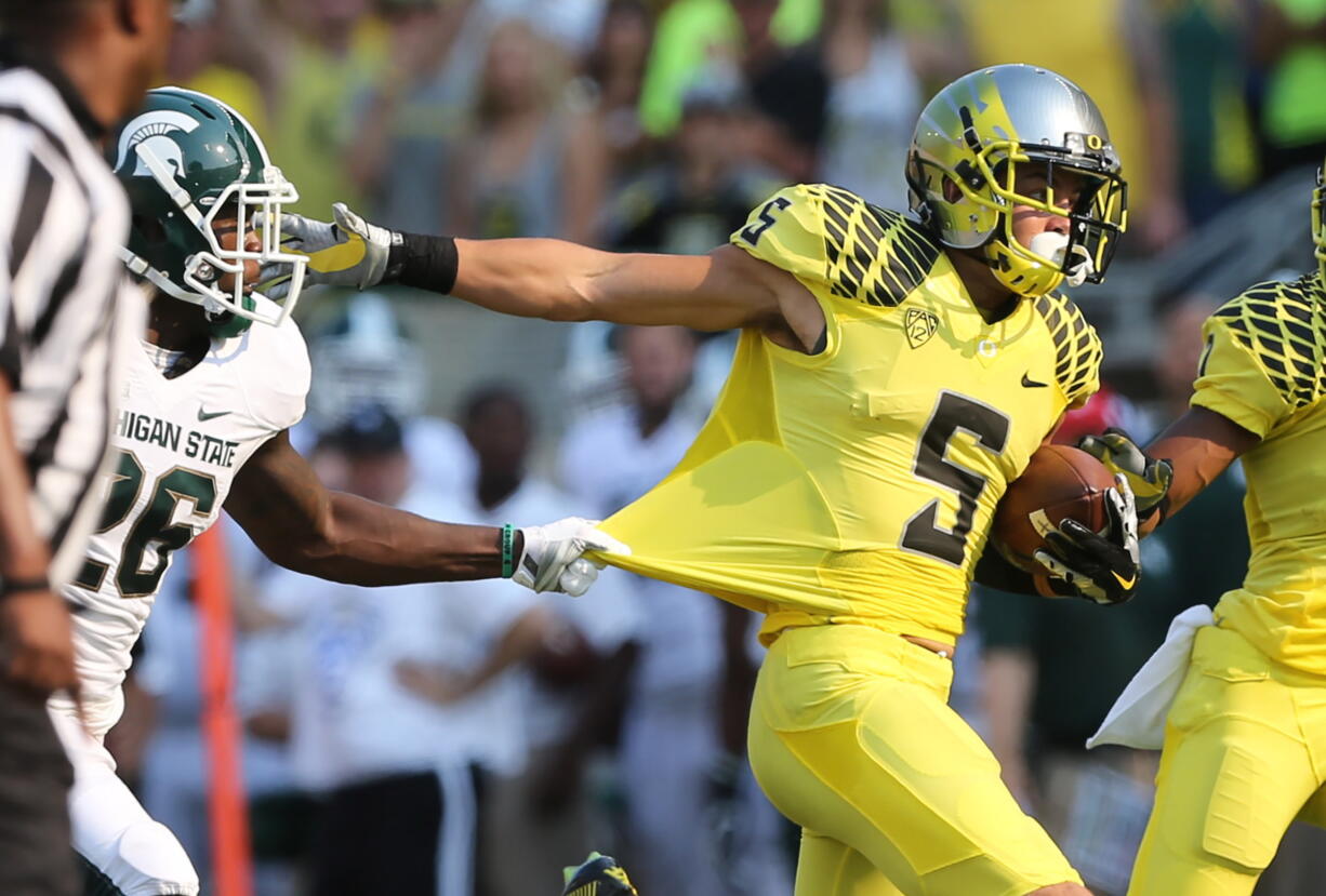 Oregon's Devon Allen (5) breaks free from Michigan State's R.J.