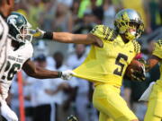 Oregon's Devon Allen (5) breaks free from Michigan State's R.J.