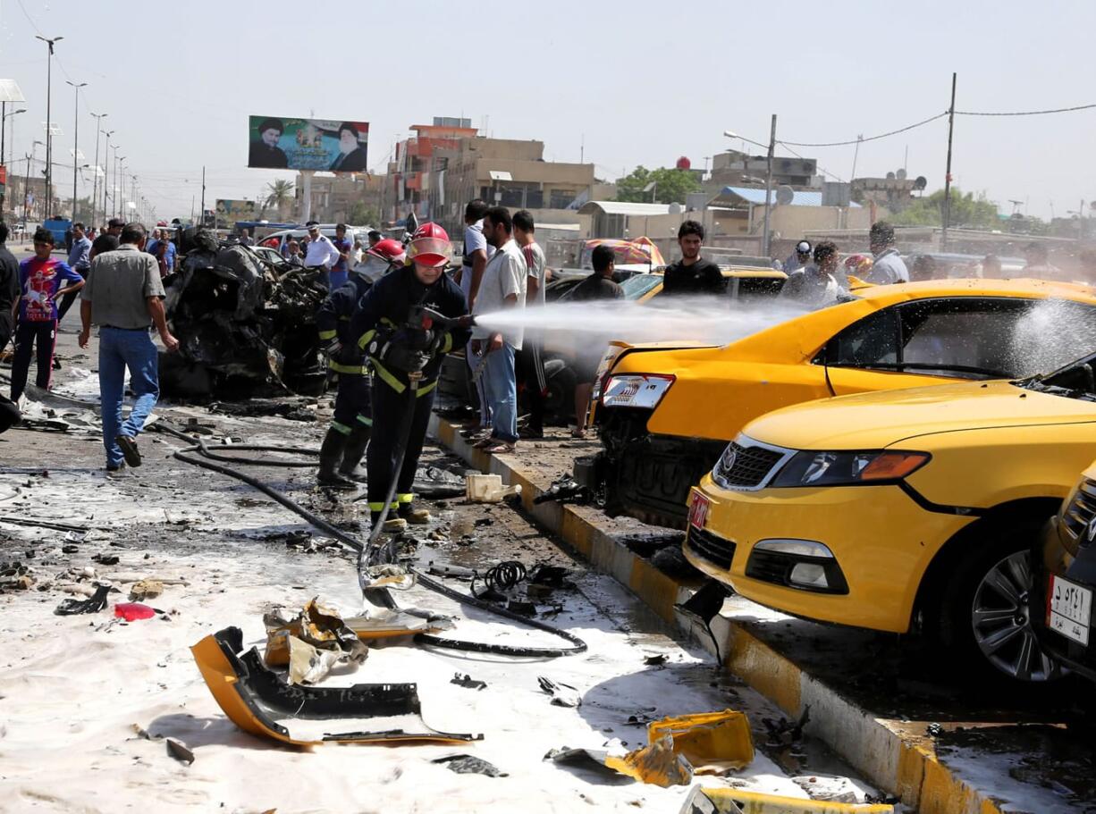 Iraqi firefighters extinguish vehicles after a car bomb explosion in the Shiite stronghold of Sadr City, in Baghdad, Iraq, on Tuesday.