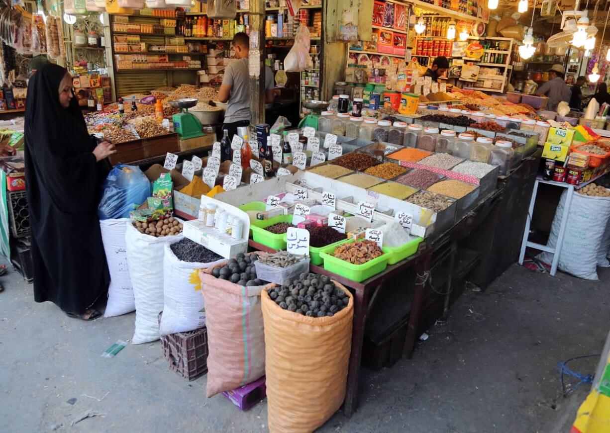 An Iraqi woman buys food at a market in Baghdad, Iraq.