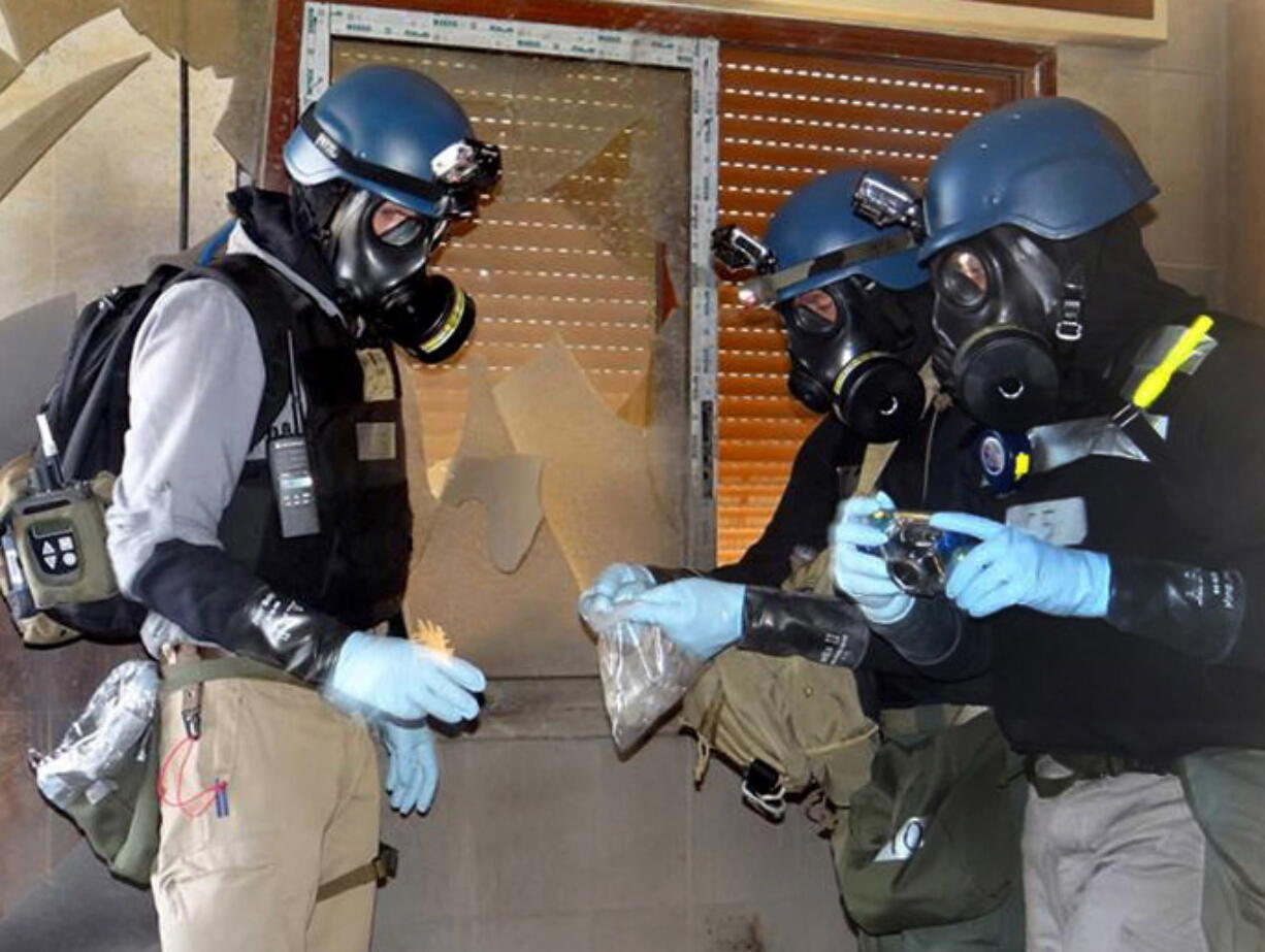 Members of the UN investigation team take samples from the ground in the Damascus countryside of Zamalka, Syria, in August.