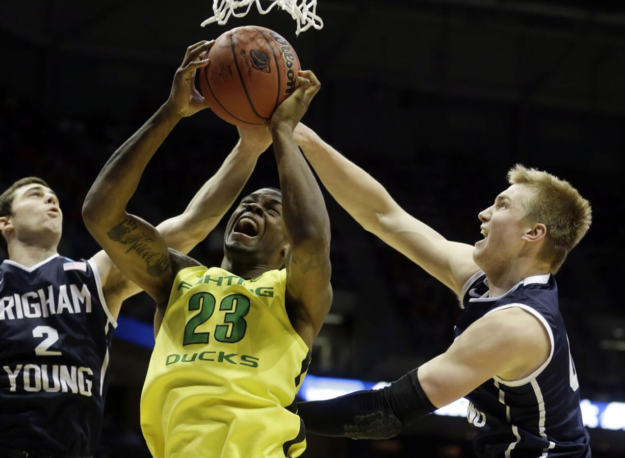 Oregon forward Elgin Cook (23) battles for a rebound against BYU guard Matt Carlino (2) and forward Eric Mika during the second half of a second-round game in the NCAA college basketball tournament Thursday in Milwaukee.