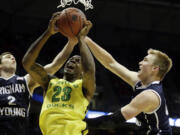 Oregon forward Elgin Cook (23) battles for a rebound against BYU guard Matt Carlino (2) and forward Eric Mika during the second half of a second-round game in the NCAA college basketball tournament Thursday in Milwaukee.