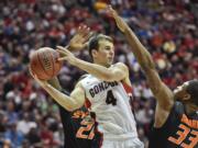 Gonzaga guard Kevin Pangos splits Oklahoma State defenders Kamari Murphy, left, and Marcus Smart while looking to pass during the first half in a second-round game in the NCAA college basketball tournament Friday, March 21, 2014, in San Diego.