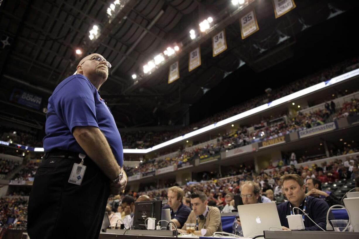 Bill Hefler of ESG Security looks up to the stands during a timeout in the second half of an NCAA college basketball game between Ohio State and Michigan in the semifinals of the Big Ten Conference tournament in Indianapolis earlier this month.