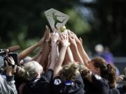FC Kansas City players lift their championship trophy after beating the Seattle Reign FC 2-1 in the NWSL championship soccer match in Tukwila on Aug. 31, 2014. The National Women's Soccer League is eying a very eventful 2015 season.