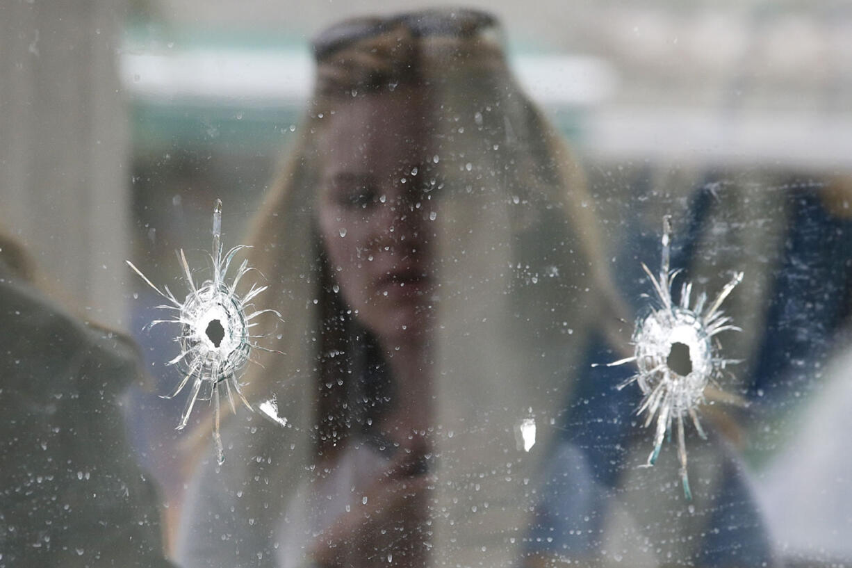 A woman looks at the bullet holes on the window of IV Deli Mark where a mass shooting took place near the University of California, Santa Barbara campus, in the Isla Vista beach community. In response to the killing rampage of Elliot Rodger, 22, that left seven people, including himself dead, lawmakers approved and California Gov.