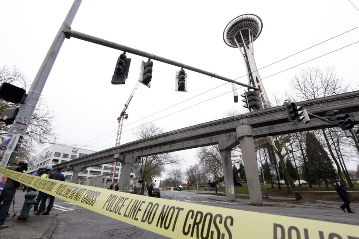 With the KOMO-TV broadcast building at left, authorities attend to the scene of a news helicopter crash near the Space Needle on Tuesday in Seattle.