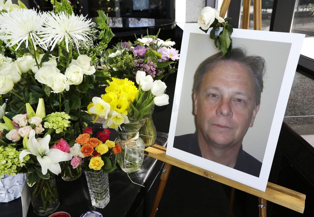 A photo of helicopter pilot Gary Pfitzner is shown at right, Wednesday in Seattle as part of a growing memorial in the lobby of KOMO-TV in memory of Pfitzner and former KOMO veteran photographer Bill Strothman, who were both killed after the helicopter they were in crashed after it took off from a helipad at KOMO-TV on Tuesday.