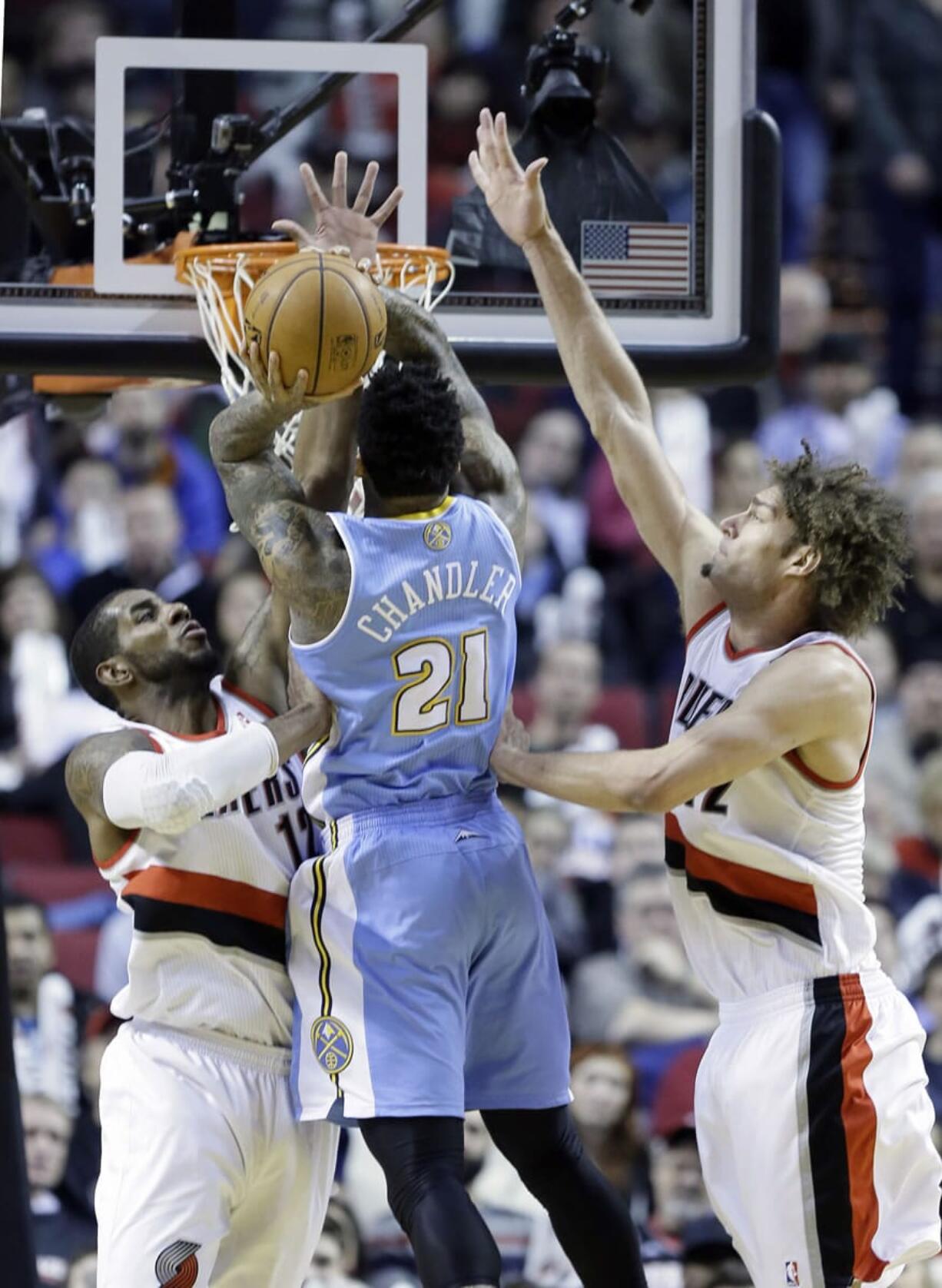 Portland Trail Blazers forward LaMarcus Aldridge, left, and Trail Blazers center Robin Lopez, right, defend Denver Nuggets forward Wilson Chandler as he shoots during the second half Thursday.