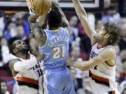 Portland Trail Blazers forward LaMarcus Aldridge, left, and Trail Blazers center Robin Lopez, right, defend Denver Nuggets forward Wilson Chandler as he shoots during the second half Thursday.